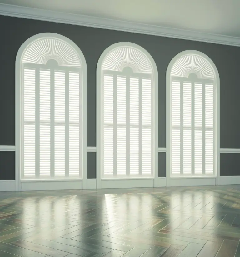 White plantation shutters on three arched windows