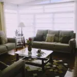 Day and night roller blinds across a living room bay window